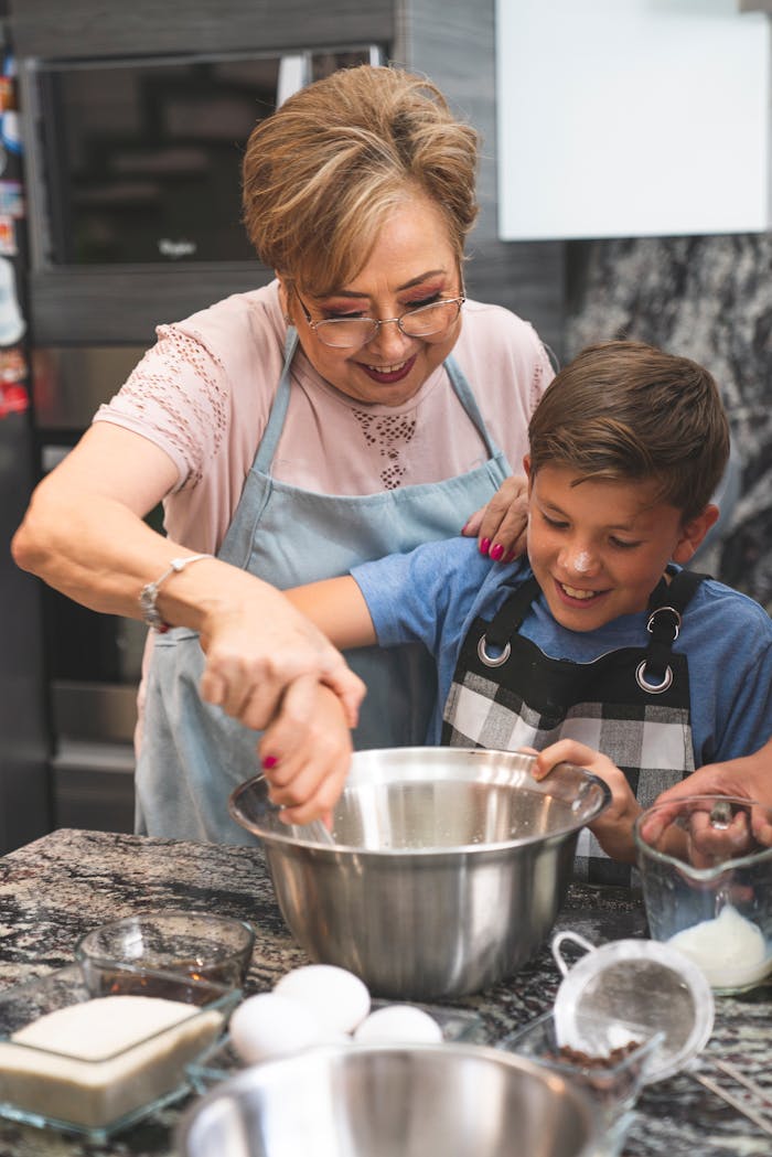 A joyful grandmother and grandson baking together in a modern kitchen.